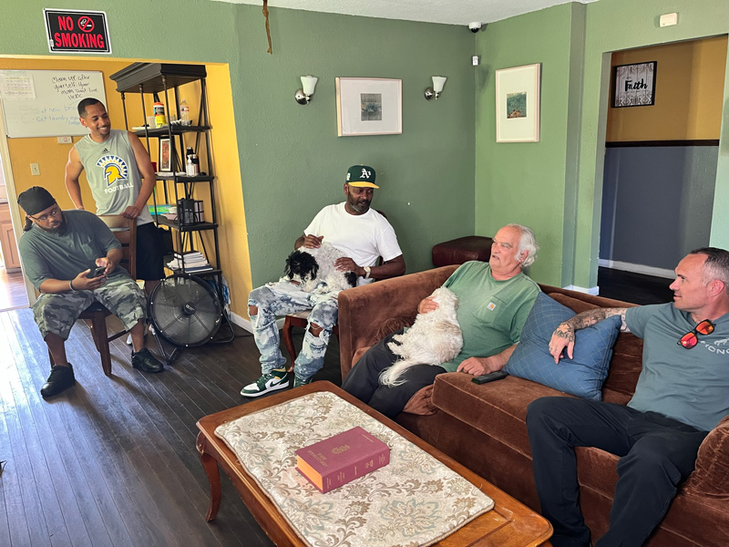 Men sitting in living room of Retraining the Village Residential Recovery Residence