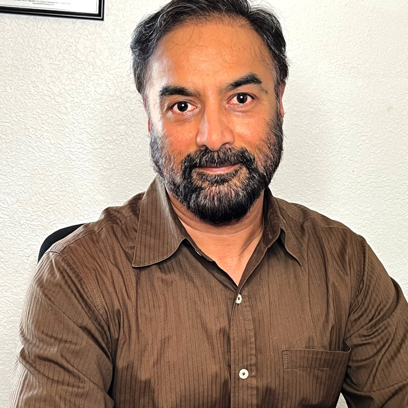 Headshot of Dr. Toor with beard and brown shirt